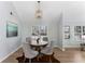 A dining room with a round wooden table, gray chairs, modern light fixture, and hardwood floors at 889 City Park Se Dr, Atlanta, GA 30312