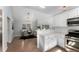 Open kitchen and dining area with stainless steel appliances, white cabinets, and hardwood floors at 889 City Park Se Dr, Atlanta, GA 30312