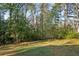 Wooded backyard with a grassy area and a bench at 11 Ivy Chase Ne, Atlanta, GA 30342