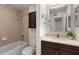 Bathroom with shower-tub combo, a dark vanity, light countertops, and glass shelving at 1445 Monroe Ne Dr # B7, Atlanta, GA 30324