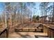 A wooden back deck with built-in seating overlooks a private, wooded backyard at 40 Brompton Dr, Dallas, GA 30157