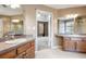 Bathroom with double vanity, wood cabinets, and doorway to carpeted bedroom at 40 Brompton Dr, Dallas, GA 30157