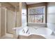 Bright bathroom featuring a soaking tub, glass shower and a large window at 40 Brompton Dr, Dallas, GA 30157