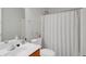 Bright bathroom featuring a single sink, wood vanity, standard toilet, and shower with a patterned curtain at 2116 Tidal Cv, Lawrenceville, GA 30043