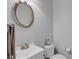 Cozy half-bathroom with a sink, mirror, toilet, and a decorative towel rack at 2116 Tidal Cv, Lawrenceville, GA 30043