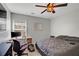 Bedroom with a neutral palette, features a ceiling fan and a computer desk setup at 2116 Tidal Cv, Lawrenceville, GA 30043