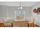 Dining area with a glass-top table and seating for six, illuminated by a modern chandelier at 2116 Tidal Cv, Lawrenceville, GA 30043