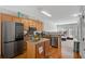 Open kitchen with stainless steel appliances, hardwood floors, wood cabinets, granite countertops and an island at 2116 Tidal Cv, Lawrenceville, GA 30043