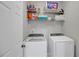 Clean laundry room featuring a white washer and dryer, shelves, and ample storage space at 2116 Tidal Cv, Lawrenceville, GA 30043