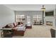 Spacious living room featuring a fireplace, a leather sofa, and bright windows at 2116 Tidal Cv, Lawrenceville, GA 30043