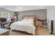 The main bedroom has a ceiling fan, hardwood floors, a work desk and a large bed with a white comforter at 2116 Tidal Cv, Lawrenceville, GA 30043