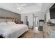 The main bedroom has a ceiling fan, hardwood floors, and a large bed with a white comforter at 2116 Tidal Cv, Lawrenceville, GA 30043