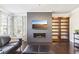 Living area featuring a gray chevron fireplace wall, hardwood floors, and built-in shelving at 2445 Santa Rosa St, Alpharetta, GA 30009