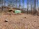 Large backyard with a greenhouse, a deck, and mature trees providing a serene setting at 5295 Ridge Rd, Douglasville, GA 30134
