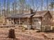 Stone-clad home featuring a charming wraparound porch and wooded surroundings at 5295 Ridge Rd, Douglasville, GA 30134