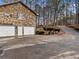 Three-car garage with ample parking space and a side yard with landscaped features at 5295 Ridge Rd, Douglasville, GA 30134