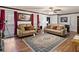 Comfortable living room featuring tan couches, hardwood floors and red curtained windows with artwork at 5295 Ridge Rd, Douglasville, GA 30134