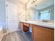 Bathroom featuring double sink vanity, tile flooring, large mirror, and neutral paint at 8504 Browns Mill Trce, Lithonia, GA 30038