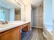 Bathroom with a double sink vanity, framed mirror, and wood-look floors at 8504 Browns Mill Trce, Lithonia, GA 30038