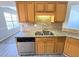 Well-lit kitchen with stainless steel dishwasher, granite countertops, and natural wood cabinets at 8504 Browns Mill Trce, Lithonia, GA 30038