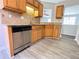 Modern kitchen with stainless steel dishwasher, wooden cabinets, and hardwood floors at 8504 Browns Mill Trce, Lithonia, GA 30038