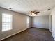 Neutral living room featuring soft carpeting, a ceiling fan, and a door to the exterior at 8504 Browns Mill Trce, Lithonia, GA 30038