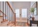 Bright foyer with hardwood floors, staircase, and decorative console table with plant at 235 Founders Mill Ct, Roswell, GA 30075
