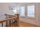 Upper hallway with hardwood floors and access to private balcony at 235 Founders Mill Ct, Roswell, GA 30075