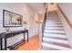 Inviting hallway with hardwood floors, staircase, and stylish artwork at 235 Founders Mill Ct, Roswell, GA 30075