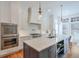 Modern kitchen featuring a large island, stainless steel appliances, and stylish pendant lighting at 235 Founders Mill Ct, Roswell, GA 30075