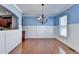 Dining room featuring blue and white walls, a modern chandelier, and hardwood floors at 247 Bell Grove Ln, Suwanee, GA 30024