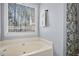 Relaxing bathroom featuring a corner bathtub and window at 118 Michael Ct, Dallas, GA 30157