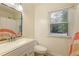 Bright bathroom with a white vanity and large mirror next to a window with a view of nature at 2189 Wood Glen Se Ln, Marietta, GA 30067