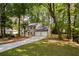 View of the gray home showing a new driveway, two-car garage and backyard access stairs at 2189 Wood Glen Se Ln, Marietta, GA 30067