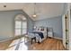 Bright main bedroom with hardwood floors, vaulted ceiling, and large arched window with plantation shutters at 4065 Delamar Dr, Cumming, GA 30041