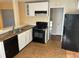 Galley kitchen with white cabinets and black appliances at 4551 Jackybell Trl, Decatur, GA 30034