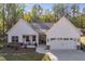 White farmhouse exterior with stone accents, two-car garage, and landscaped yard at 728 Harmony Rd, Temple, GA 30179