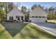 White farmhouse exterior with stone accents, two-car garage, and landscaped yard at 728 Harmony Rd, Temple, GA 30179