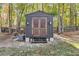 Dark gray shed with double wooden doors, surrounded by trees at 728 Harmony Rd, Temple, GA 30179