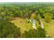 Aerial view showcases a home nestled among the trees and adjacent to the road, surrounded by lush greenery at 3119 E Fairview Rd, Mcdonough, GA 30252