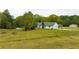 Sprawling property featuring a white-sided home, expansive yard, above-ground pool, and basketball hoop at 3119 E Fairview Rd, Mcdonough, GA 30252