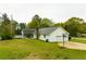 Rear exterior view featuring a screened-in porch, deck, spacious yard, and convenient two-car garage at 3119 E Fairview Rd, Mcdonough, GA 30252