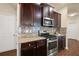Kitchen features dark brown cabinets, granite countertops, and stainless steel appliances at 116 Centennial Ridge Dr, Acworth, GA 30102