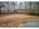 Expansive backyard with mature trees and partially fenced border, offering privacy and potential at 6520 Chickasaw Dr, Douglasville, GA 30135