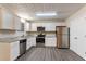 Bright kitchen featuring stainless steel appliances, white cabinets, and granite countertops, with wood flooring at 100 Arthurs Ln, Covington, GA 30016