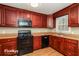 Kitchen with dark wood cabinets and black appliances at 2105 Cornerstone Sw Ln, Marietta, GA 30064