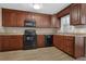 Kitchen with dark wood cabinets and black appliances at 2105 Cornerstone Sw Ln, Marietta, GA 30064