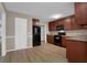 L-shaped kitchen with dark wood cabinets and black appliances at 2105 Cornerstone Sw Ln, Marietta, GA 30064