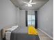 Bright bedroom with ceiling fan, large window, and gray bedding at 250 Pharr Ne Rd # 413, Atlanta, GA 30305