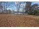 Large backyard with home view and leaf covered ground at 280 Belmont Farms Dr, Ellenwood, GA 30294